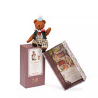 Teddy bear in a checkered outfit with a decorative box on a white background