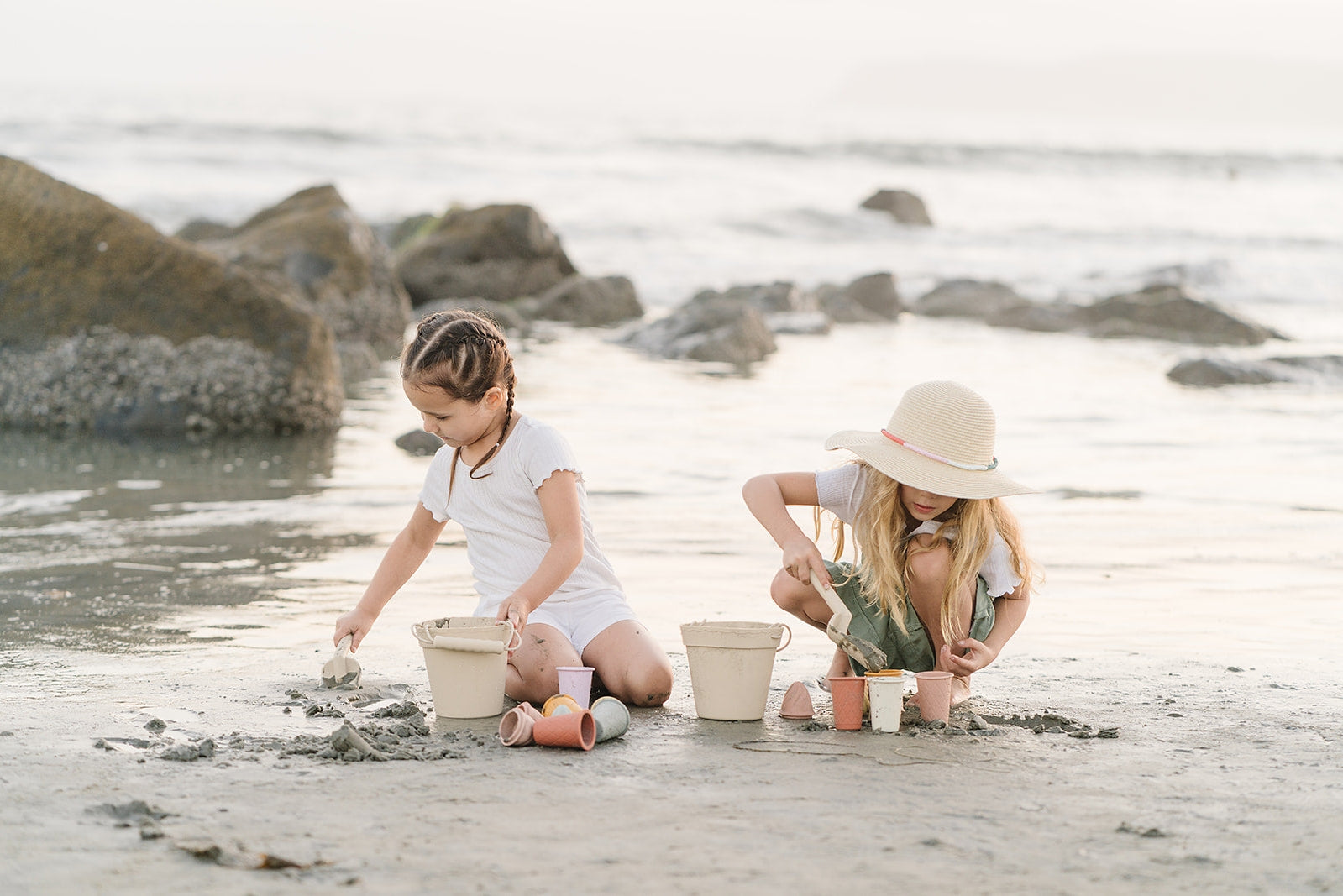 2 Young girl playing with sand toys on a beach
