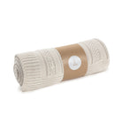 Rolled-up beige blanket with a brown paper wrap and white label on a white background