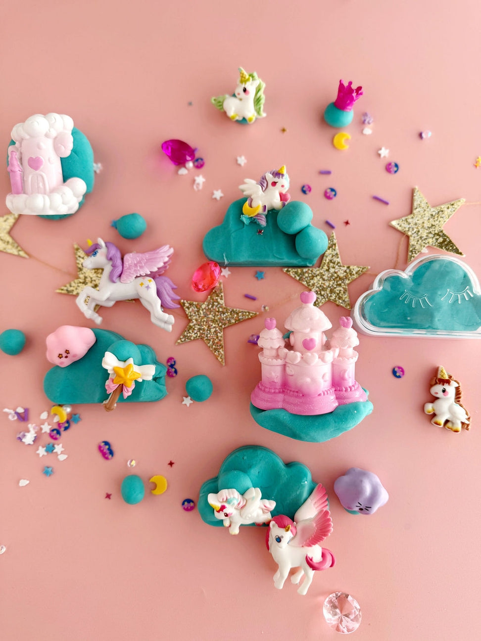 Colorful toy figures of unicorns and castles on a pink background