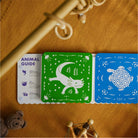 Children's educational cards on a textured surface with toys around