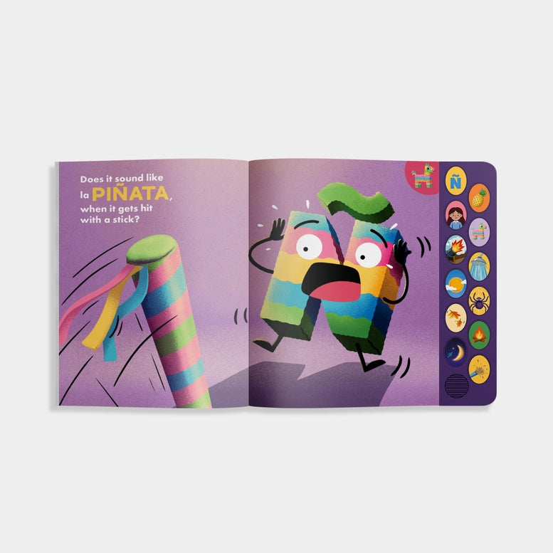 An open copy of "What Does Ñ Sound Like?: A Spanish-English Sound Book," showing an interior illustrated spread with the text "Does it sound like la PIÑA, when it gets hit with a stick?" on the left page, an animated piñata character reacting as a stick approaches on the right page, and a vertical panel of interactive sound buttons along the right edge.