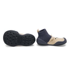 Navy and beige sock-style shoes on a white background