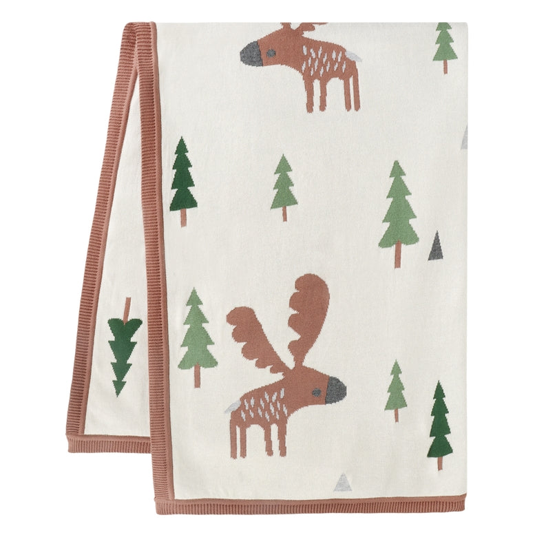 A folded cream-colored baby blanket or towel with a brown moose and green pine tree pattern, featuring a dusty rose ribbed border.