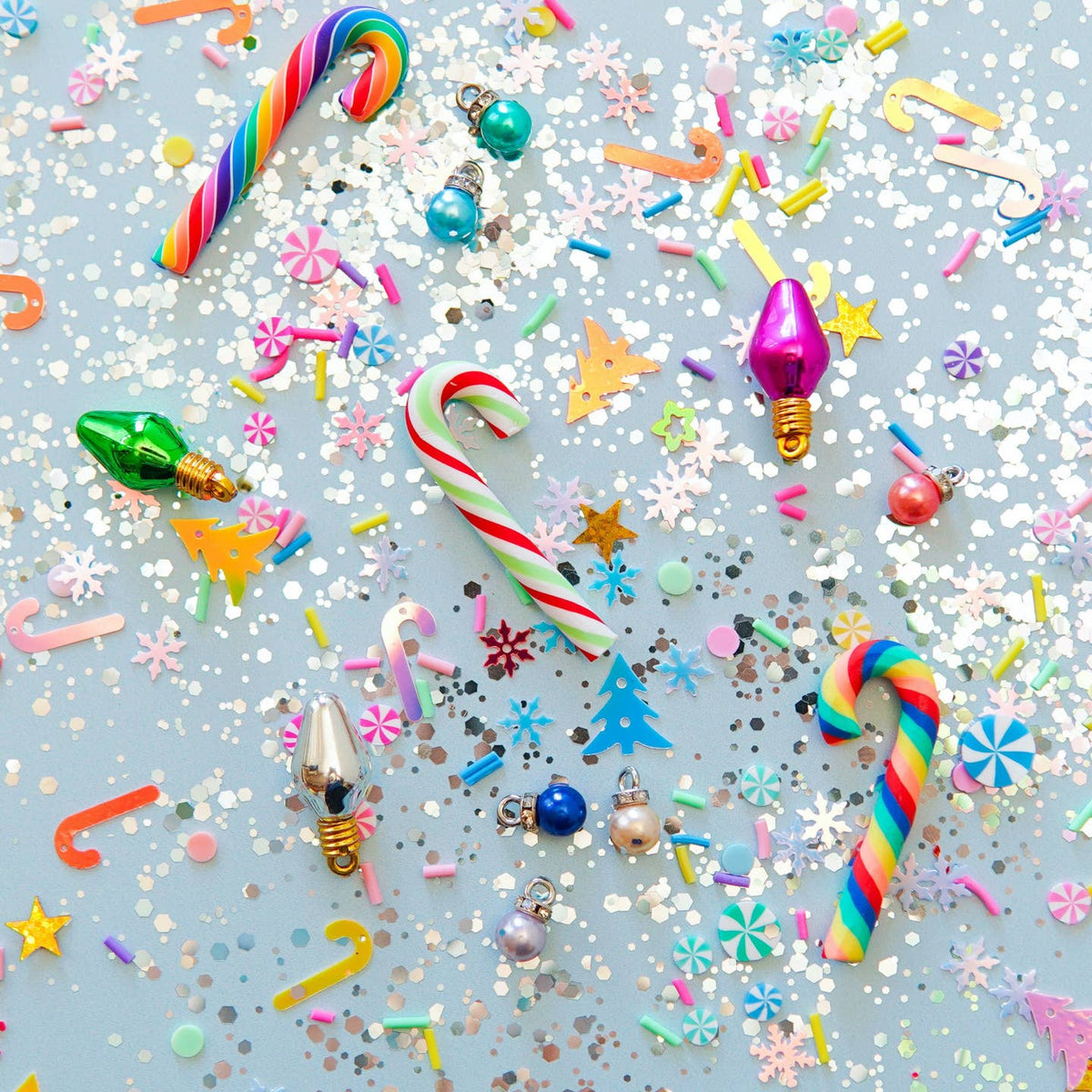 Colorful Christmas ornaments and confetti on a light blue background