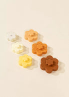 Set of flower-shaped rubber stamps in various colors on a beige background