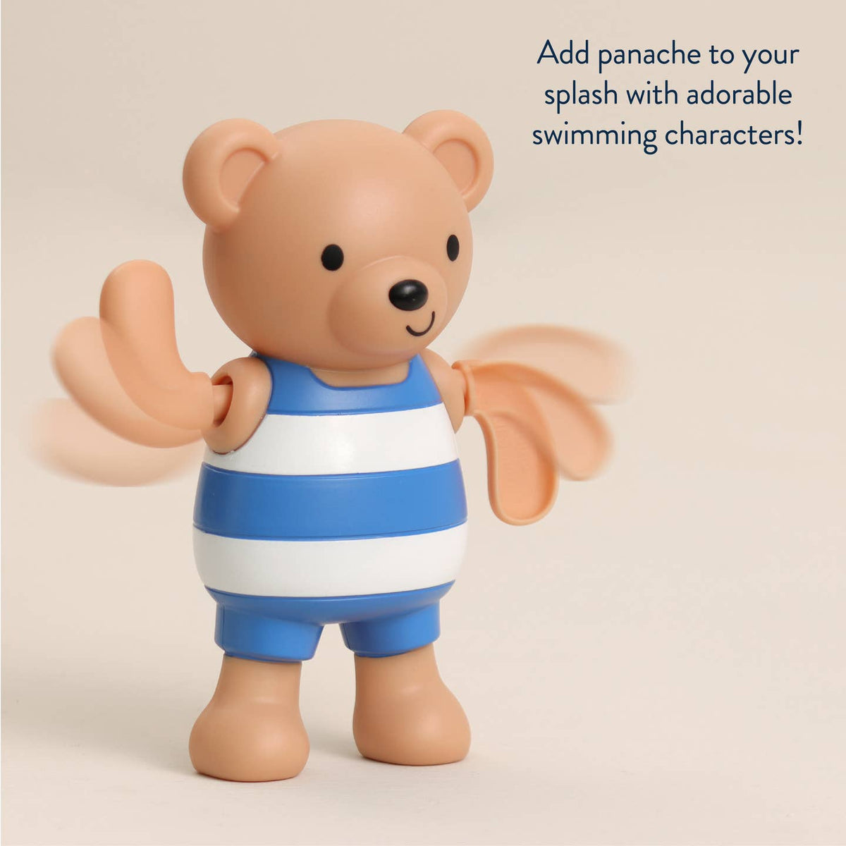 Toy bear in a blue and white striped swimsuit on a beige background