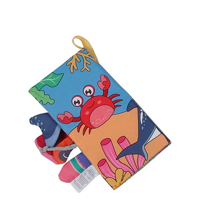A colorful baby soft toy featuring a cartoon crab on an underwater theme, with a yellow hanging loop at the top and a small fabric tag attached.