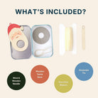 An informational product graphic titled 'WHAT'S INCLUDED?' showing the contents of a wooden keepsake gift set: an open keepsake tin with a wooden Santa face ornament, a wooden base ring, a white cord, a wooden stick tool, and four colored circles labeled 'Wool & Wooden Needle,' 'Wooden Santa Base,' 'Pom Pom Makers,' and 'Kempsake Tin.'.