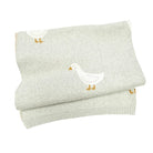 Folded light gray blanket with a duck design on a white background
