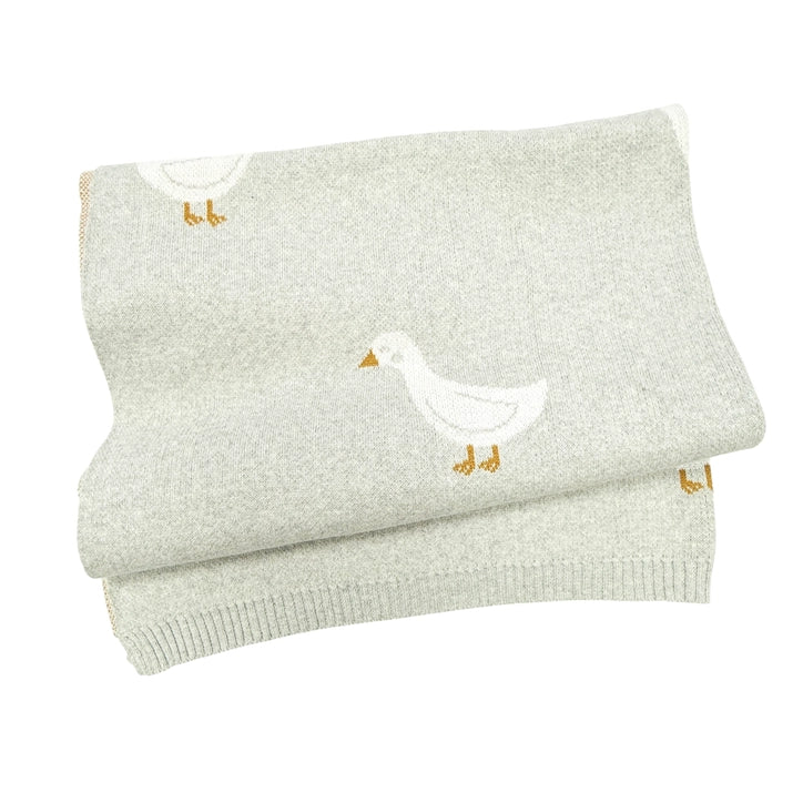 Folded light gray blanket with a duck design on a white background