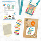 Cross-stitching kit with pre-printed patterns, colored threads, and a cardboard box on a white background.