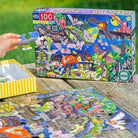 Glow-in-the-dark puzzle with colorful packaging and scattered pieces on a wooden surface.