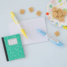 Notebook, pen, and cookies on a light blue surface