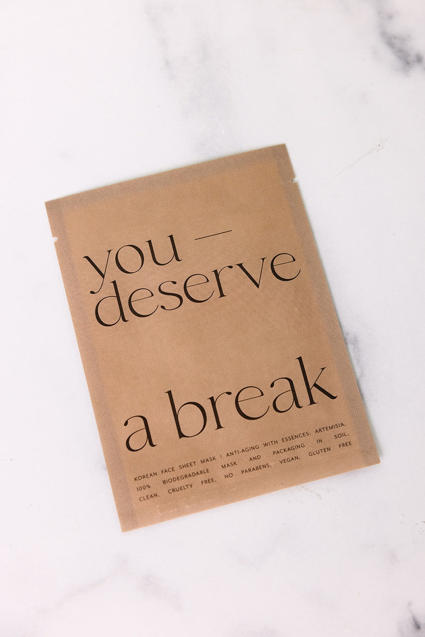 Kraft paper product packaging with 'you deserve a break' text on a marble surface