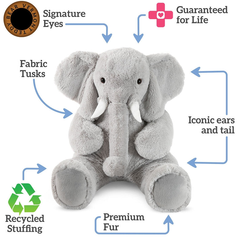 A plush gray elephant toy with white tusks, black bead eyes, and soft textured fur and features, sitting against a plain white background.