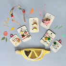 Yellow wedge-shaped bag with decorative items on a gray background