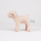 A small plush sheep toy in a soft cream bouclé fabric, standing on a seamless white studio background. A small paper brand tag reading 'Les petits.