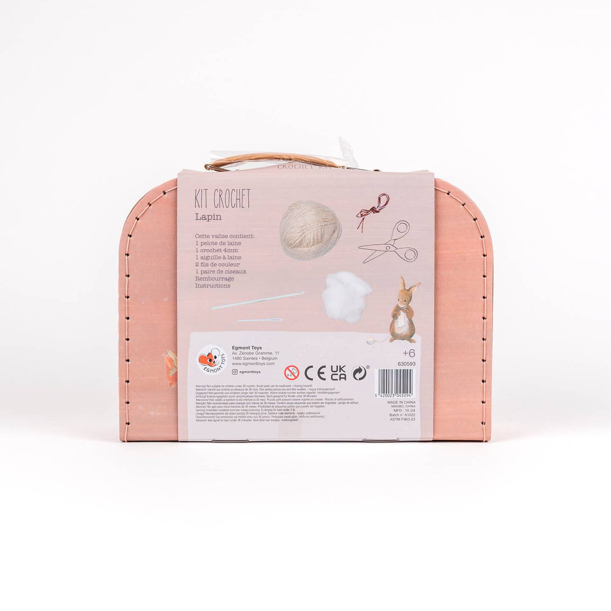 Pink crochet kit packaging with yarn, hooks, and scissors on a white background
