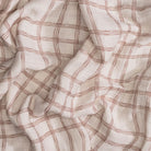 Close-up of beige fabric with red plaid pattern