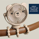 Beige fan with bear design attached to a brown handle, on a light gray background.