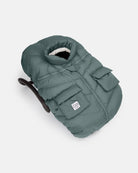 Green baby carrier with a white label on a light gray background