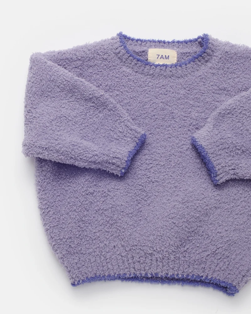 A lavender purple textured fleece crewneck sweater with long sleeves, laid flat on a white background. The brand label inside the collar reads '7AM'.