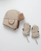 Beige winter hat and mittens set on a white background
