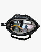 Black diaper bag open with baby items on a white background