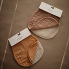 Two baby bibs with tags on a brown background