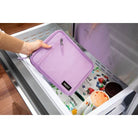 Purple pouch being placed into a dishwasher with a focus on the brand 'Pacsafe'.