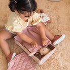 Child playing with a doll on a carpeted floor