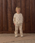 A child wearing the Rylee + Cru Winter Bears matching long-sleeve sweatshirt and pant set featuring an all-over patterned bear print.