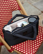 Black bag with compartments on a red and beige checkered chair