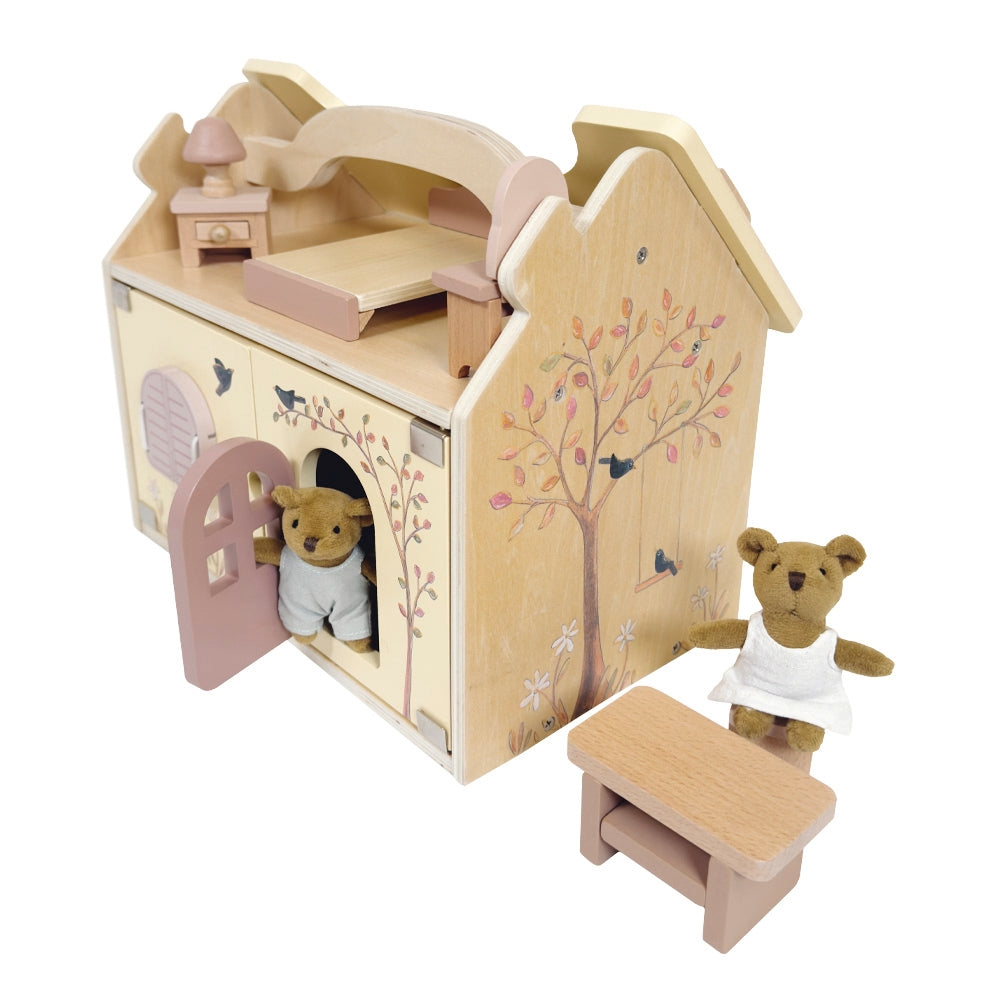 Wooden toy house with teddy bear and bench on a white background