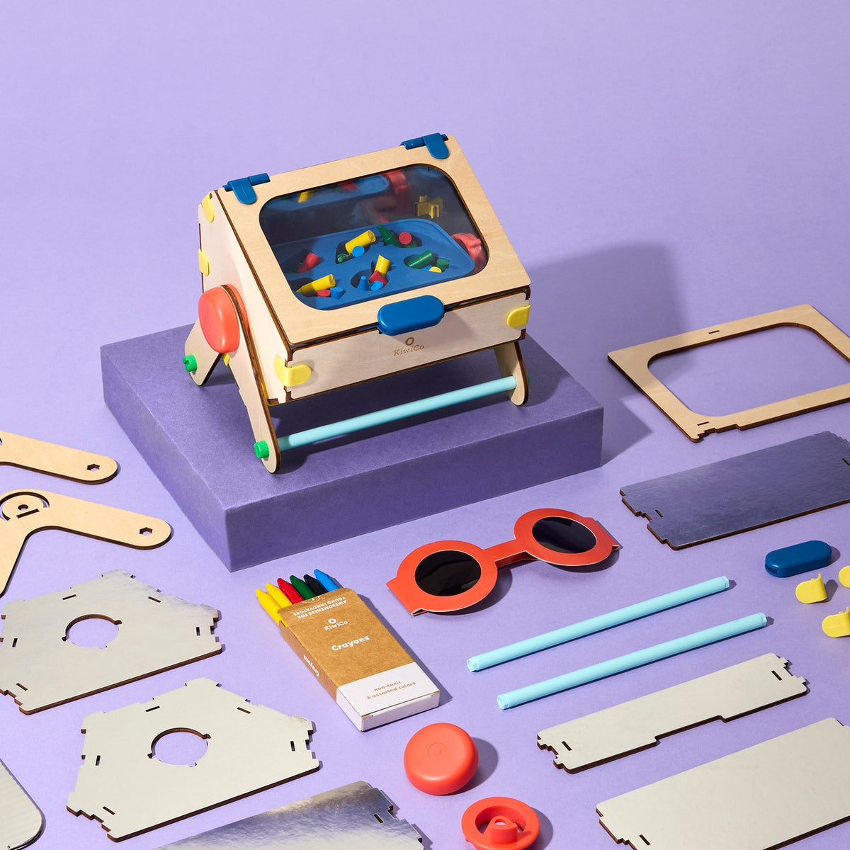 Wooden toy assembly kit with components on a purple background
