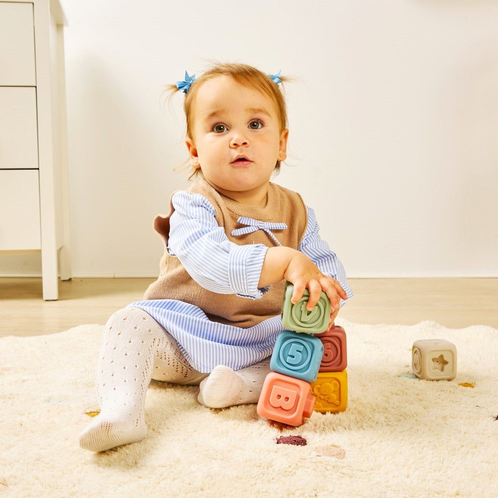 Child playing with colorful blocks on a carpeted floor