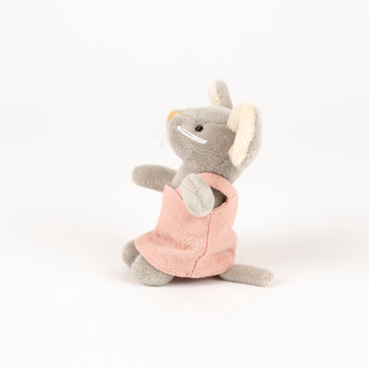 A small plush mouse toy in gray with beige ears, wearing a pink dress, photographed on a clean white background.