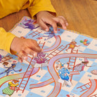 Child playing with a colorful board game on a wooden floor