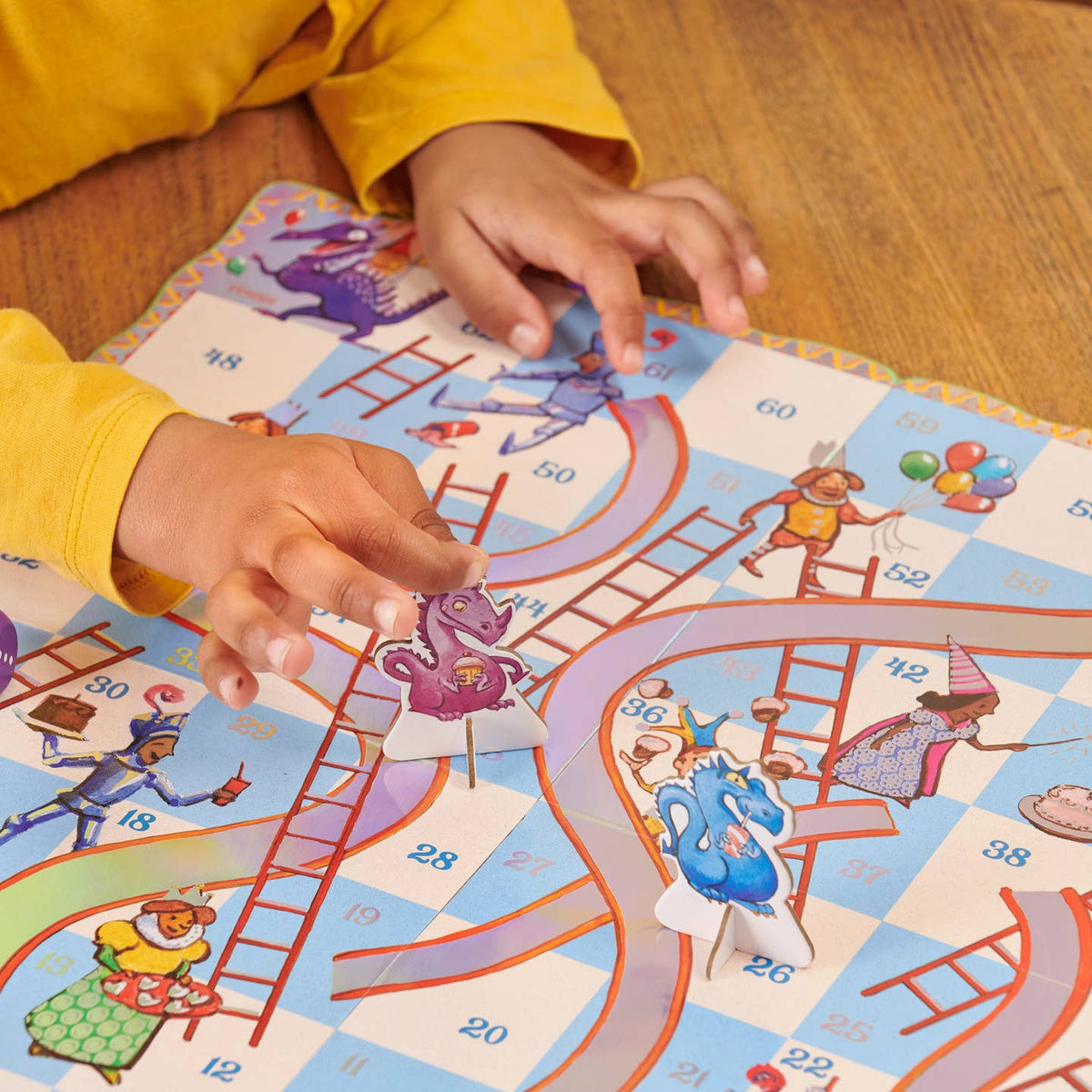 Child playing with a colorful board game on a wooden floor