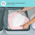 Person placing a pink and white cushion into a suitcase with text 'Lightweight and Portable' on a teal background.
