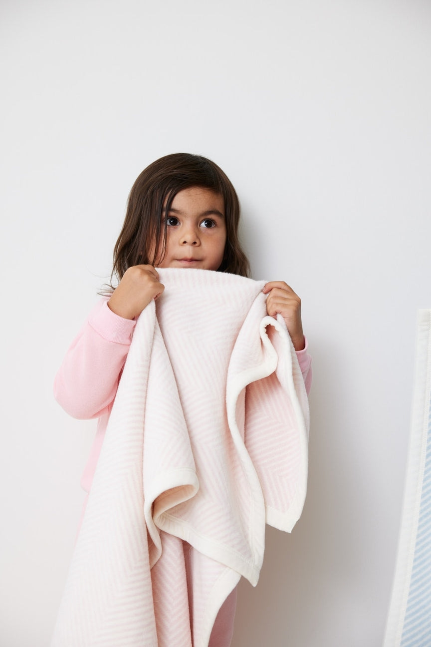Children with pink and cream chevron pattern blanket
