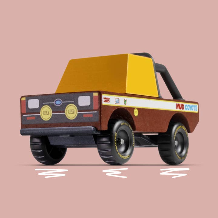 Toy truck with a yellow bed and brown body on a pink background