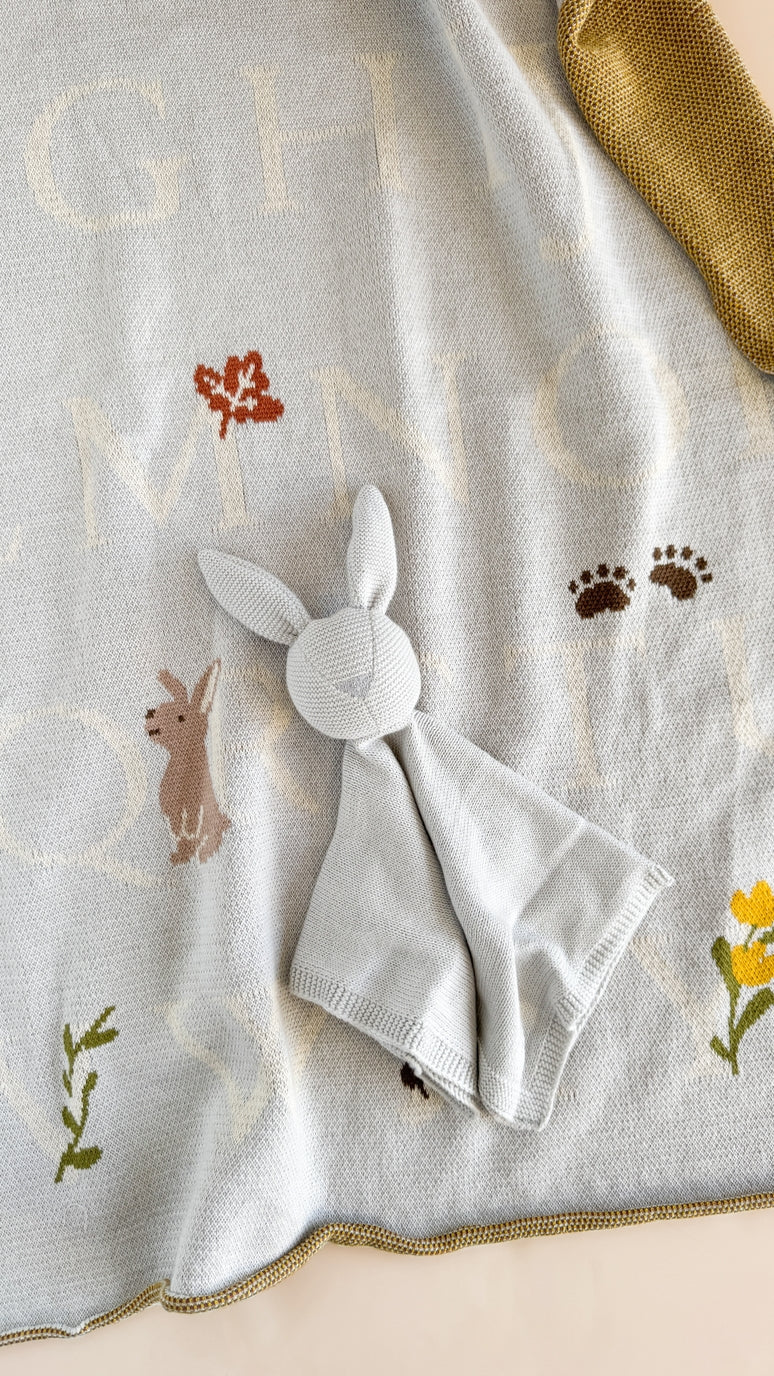 Embroidered blanket with animal designs and a white napkin on top