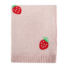 Pink knitted blanket with strawberry patterns on a white background