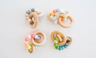 Set of colorful wooden baby teething rings on a light background
