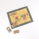 Wooden board game with caterpillar and leaf pieces on a white background