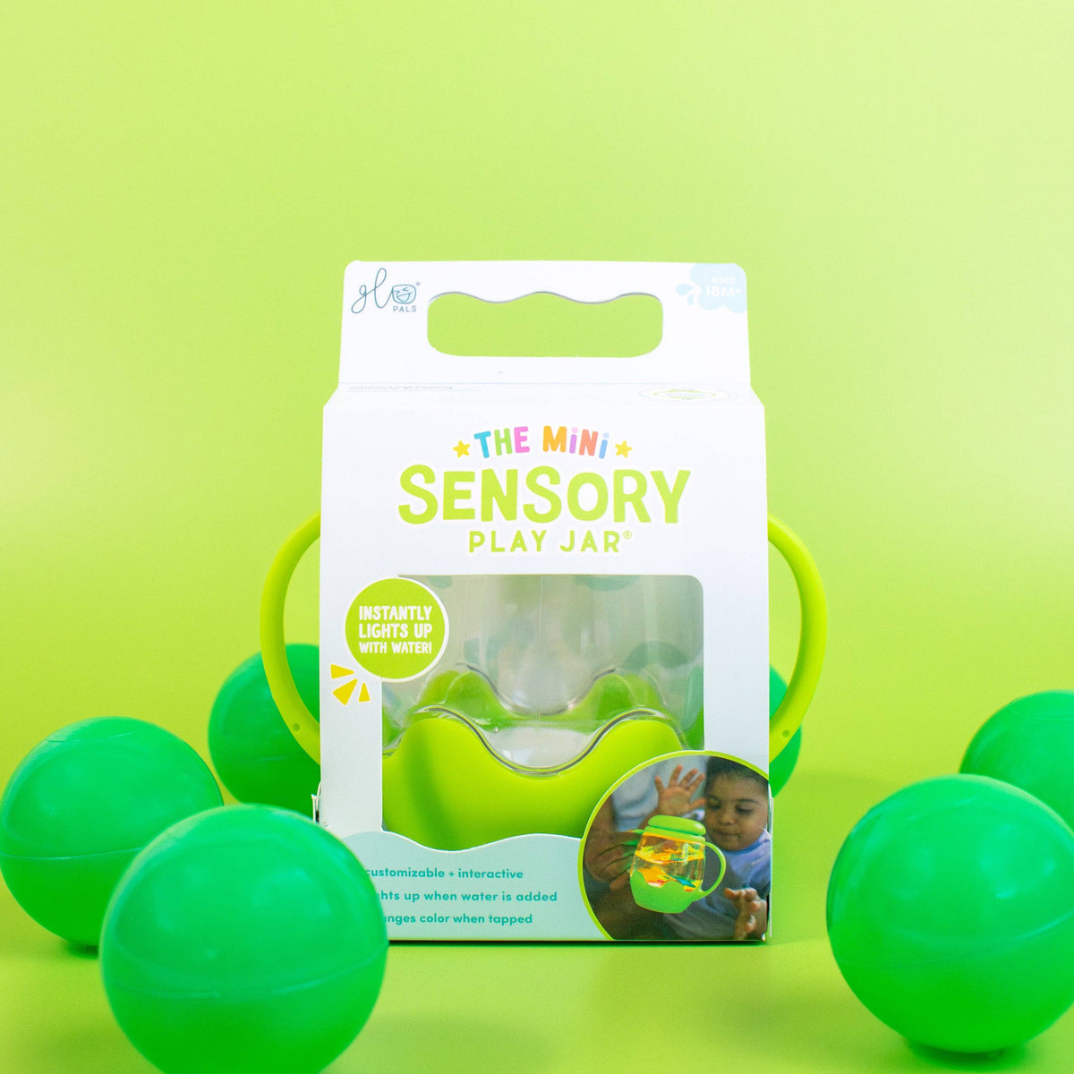 Green sensory play jar packaging with green balls on a green background