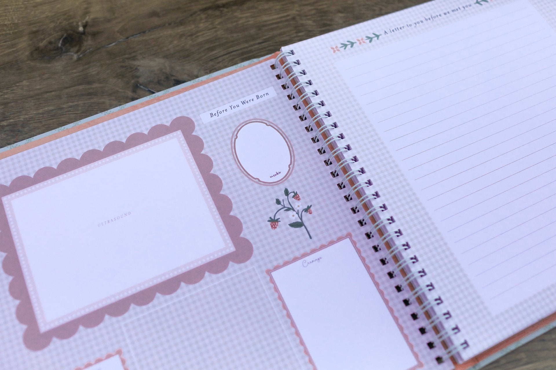 Open spiral-bound notebook with decorative pages on a wooden surface