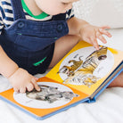 Child reading a book with pictures of tigers